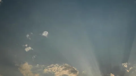 Timelapse of moving late day clouds and strong sun rays projecting from the Stock Footage 340990778