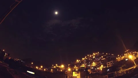Timelapse of a night with clouds and moon, shows urbanized and illuminated hill. Stock Footage 147961189