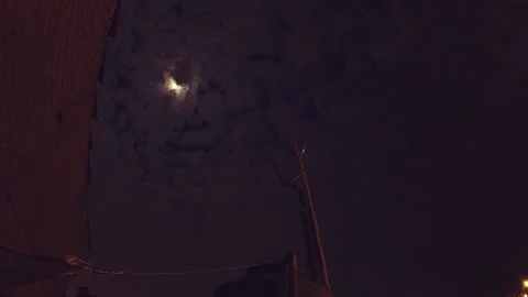 Timelapse of a night with clouds and moon, shows urbanized and illuminated hill. Stock Footage 147961193