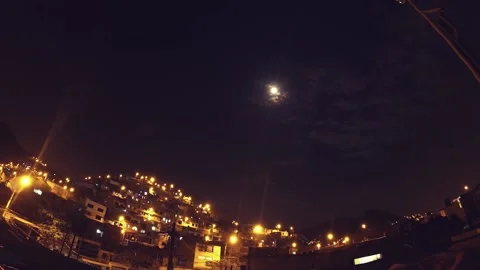 Timelapse of a night with clouds and moon, shows urbanized and illuminated hill. Video stock 147961250