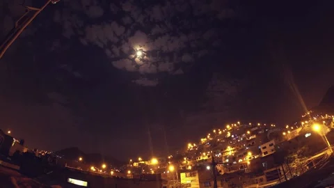 Timelapse of a night with clouds and moon, shows urbanized and illuminated hill. Video stock 147961255