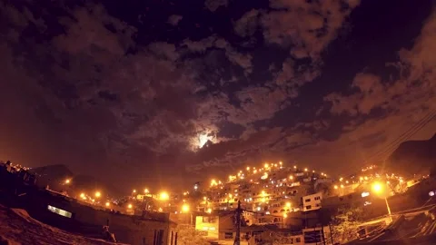 Timelapse of a night with clouds and moon, shows urbanized and illuminated hill. Video stock 147961858