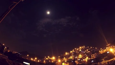 Timelapse of a night with clouds and moon, shows urbanized and illuminated hill. Video stock 147961905