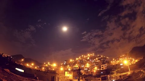 Timelapse of a night with clouds and moon, shows urbanized and illuminated hill. Video stock 147961913