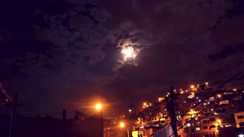 Timelapse of a night with clouds and moon, shows urbanized and illuminated hill. Stock Footage 147961919