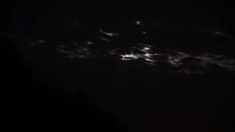 Timelapse of the night sky, the moon Peeps through the clouds Stock Footage 127893153