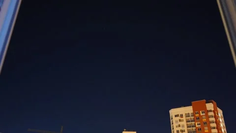 Timelapse of the night sky from the window of an apartment building. Stock Footage 139148666