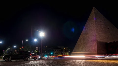 Timelapse of night traffic alongside the Piramide Cestia, Rome Stock Footage 133788674