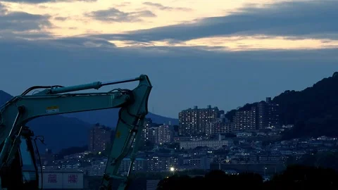 Timelapse night view of an excavator and mountain town lights in Japan,4K Stock Footage 346621900
