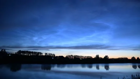 Timelapse of noctilucent clouds in the reflection of the lake 4k Stock Footage 237298419