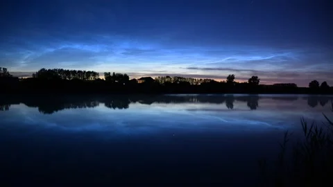 Timelapse of noctilucent clouds in the reflection of the lake 4k Stock Footage 237298483