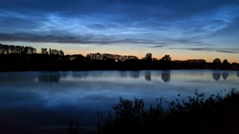 Timelapse of noctilucent clouds in the reflection of the lake 4k Stock Footage 237298485