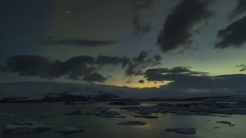 Timelapse of northern lights and clouds moving over the lagoon during evening Stock Footage 73010712