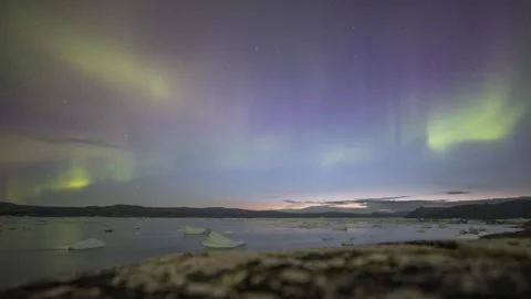 Timelapse of Northern Lights dancing over ice fjord of East Greenland Stock Footage 332382094