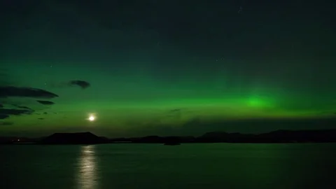 Timelapse of northern lights passing over craters and lake at night Stock Footage 73010933