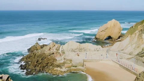 Timelapse of ocean waves washing over rocky cliffs in portions during sunny day Stock Footage 156269013