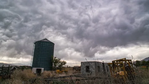 Timelapse of odd clouds moving over old farm equipment during storm Stock Footage 153391169