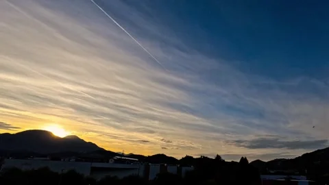 Timelapse of orange sunset with blue sky and hills Video stock 318643566