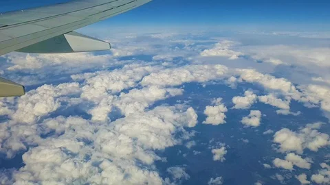 Timelapse out of airplane passenger window with clouds below Stock Footage 129433021