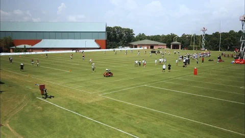 Timelapse pan left to right of athletes practicing on football field Stock Footage 105425355