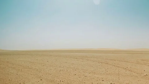 Timelapse pan of windy desert landscape with dunes in the distance Video stock 78584645