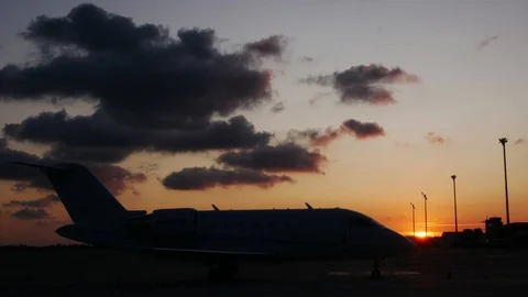 Timelapse  of a parked private jet with the sun setting down in the Stock Footage 114889425