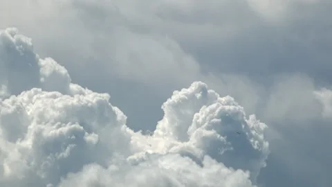 A timelapse of a passenger aircraft passing in front of billowing Cumulous Stock Footage 338053023