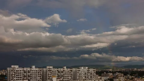 Timelapse of passing clouds and rainbow over pune city Stock Footage