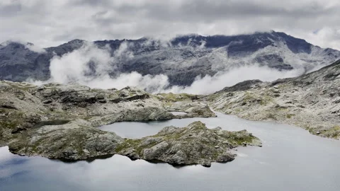 Timelapse of passing clouds and shadows over alpine lake - Static mountain view Stock Footage 328406105