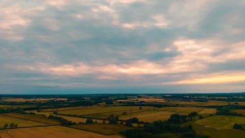Timelapse patchwork farmland beneath colorful sunset cloudscape. Panoramic 動画素材 338068923