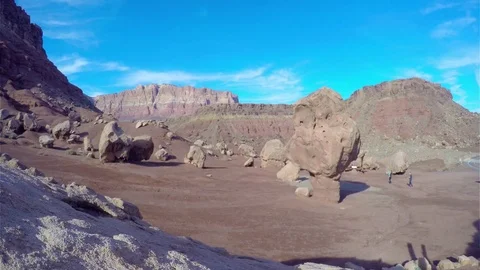 Timelapse of people walking around large stones, at a red desertf , like th.. Stockbeeldmateriaal 72425006