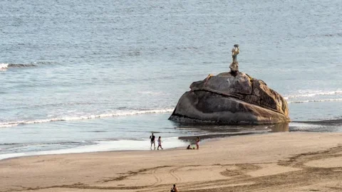 Timelapse of people walking by the Pedra Da Feiticeira statue in Sao Vicente Stock Footage 271627579