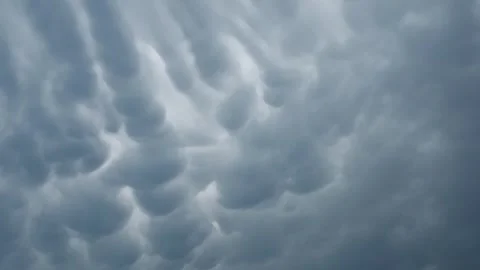 Timelapse of pillowy Mammatus Clouds moving across the sky in shades of Stock Footage 340990692