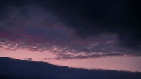 Timelapse of pink and black sunset clouds over the mountains Video stock 180542728