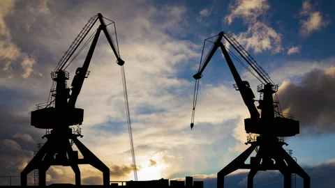 Timelapse of port cranes at sunset. Cargo transportation by sea. Stock Footage 165732430
