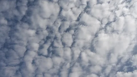 Timelapse of Puffy White Summer Clouds Drifting Across a Bright Blue Sky on a Stock Footage 332068335