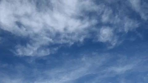 Timelapse of puffy white summer clouds arranged in long row move across a dark Stock Footage 335215098