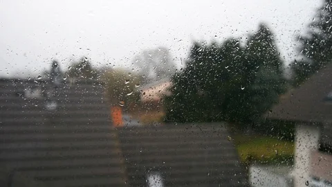 Timelapse of rain, drops sliding down the window, blured background houses Stock Footage 104129771