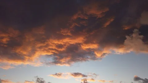 Timelapse of red clouds moving fast over blue sky during last minutes of sunset Video stock 123390721