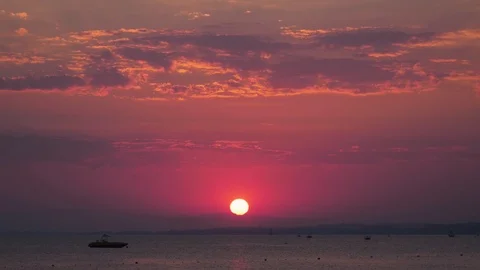Timelapse red sun light reflects off clouds as sun sets over mediterranean oc Stock Footage 97975066