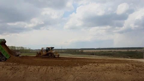 Timelapse Road construction trucks pour graph and sand. Видео 117960212