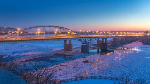 TIMELAPSE: Road traffic on a bridge over a frozen river. Winter landscape Stock Footage 84276392