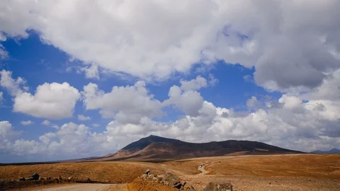 Timelapse of a road to a volcano under fast moving white clouds Lanzarote 4K Stock Footage 89148349