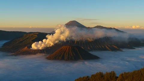 Timelapse of rolling cloud and smoke against mountain during sunrise in Bromo 動画素材 90526092