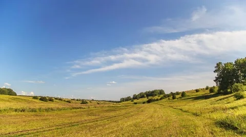 Timelapse Rolling clouds over green field/flowers. Stock Footage 52378427