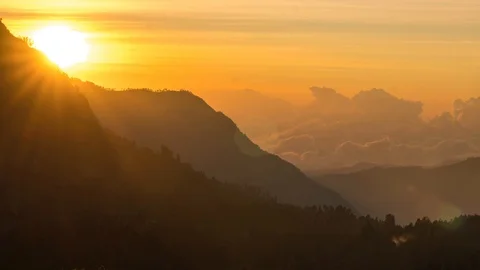 Timelapse of rolling clouds with sun rising near mountain. 4K UHD. Stock Footage 96341615