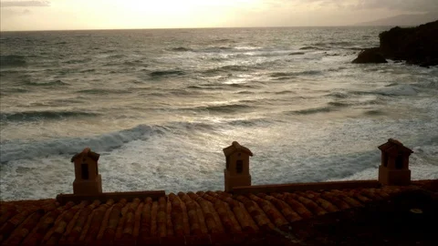 Timelapse Rough sea in front of an ancient italian village at sunset Video stock 102053932