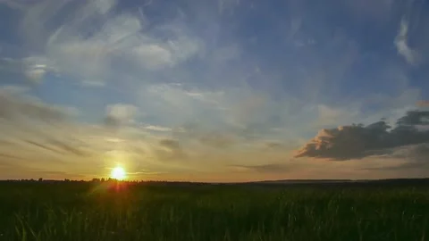 Timelapse of running clouds across the blue sky in a field at sunset. Russia Video stock 140582398