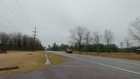 Timelapse at a rural 4 way intersection with one way stop signs on a cloudy r Stock Footage 148970195