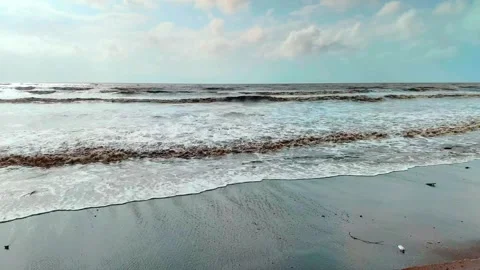 Timelapse of sea waves crashing on shore under blue sky Stockbeeldmateriaal 345320323